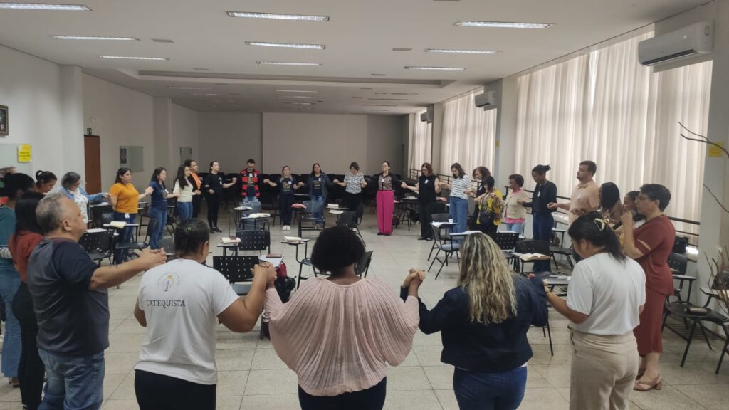 Catequistas da Diocese de Uberlândia rezam de mãos dadas emo em encontro de formação na PUC-SP